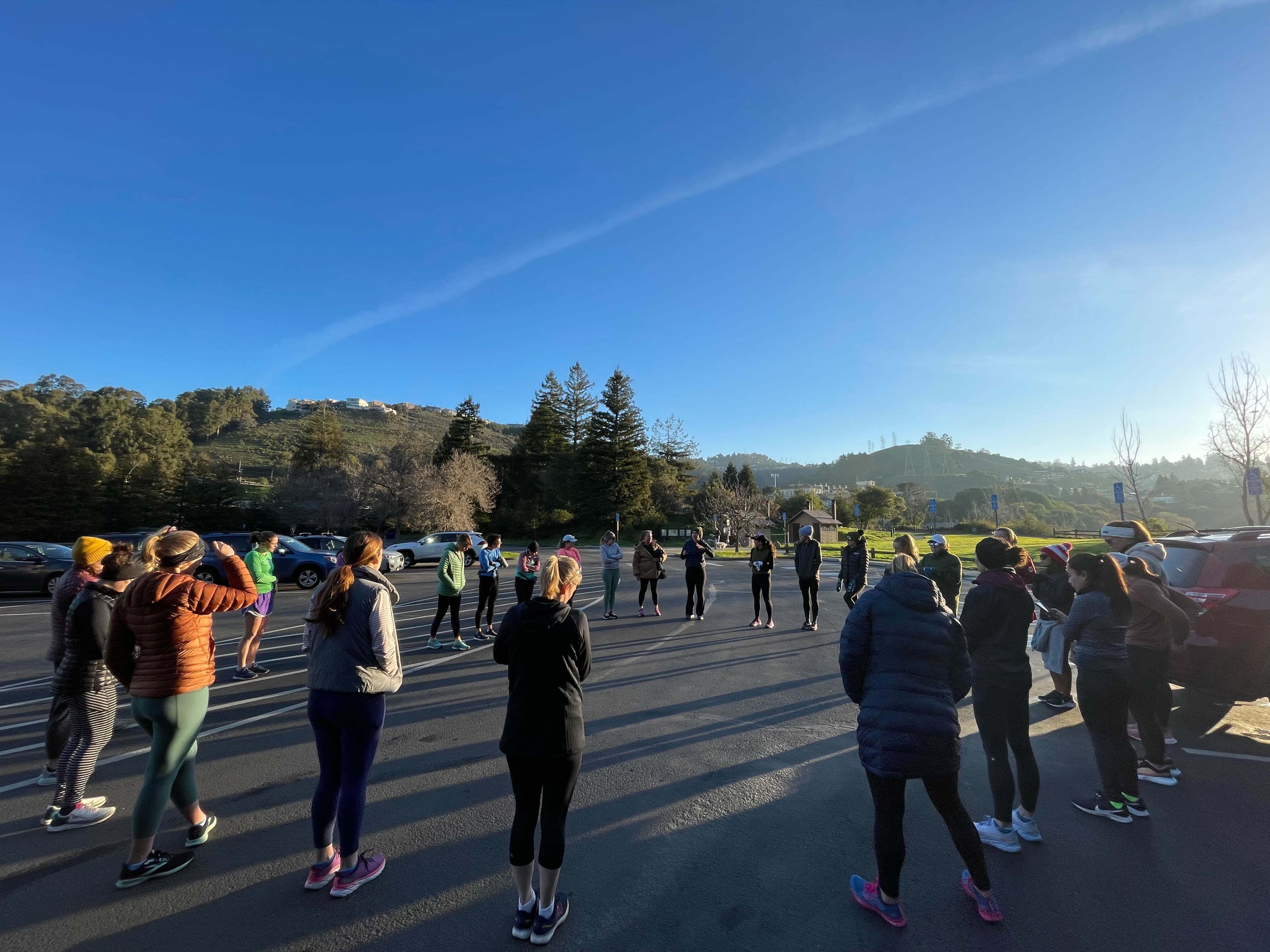 group of women in running gear circled up